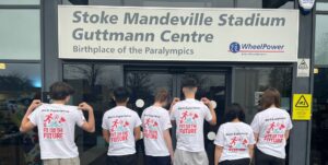 Group of six young people outside Stoke Mandeville Stadium with matching ' fit for the future ' t-shirts
